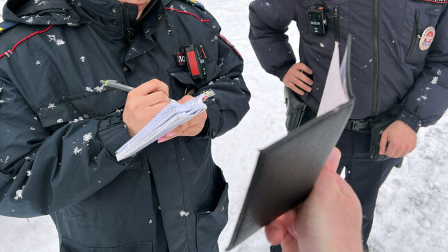 Сотрудники полиции переписывают данные Дениса КАРАГОДИНА